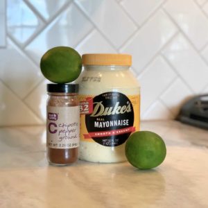 Mayonnaise and limes on a counter top.