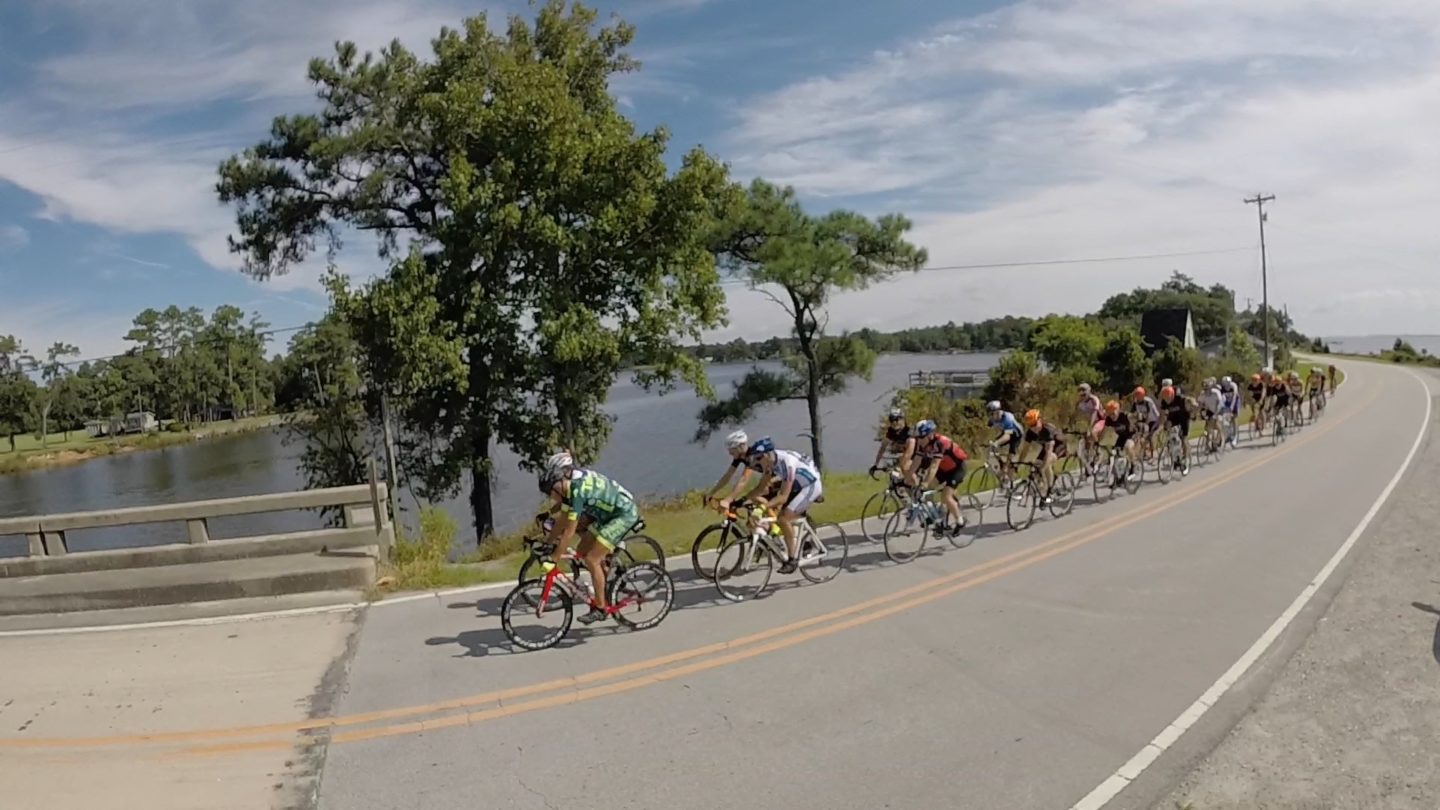 Group of cyclists riding down the road.