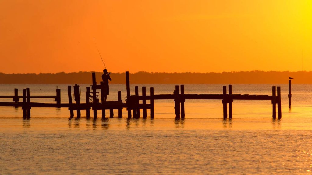 Fisherman casting into the Neuse River at sunset in Pamlico County, NC.